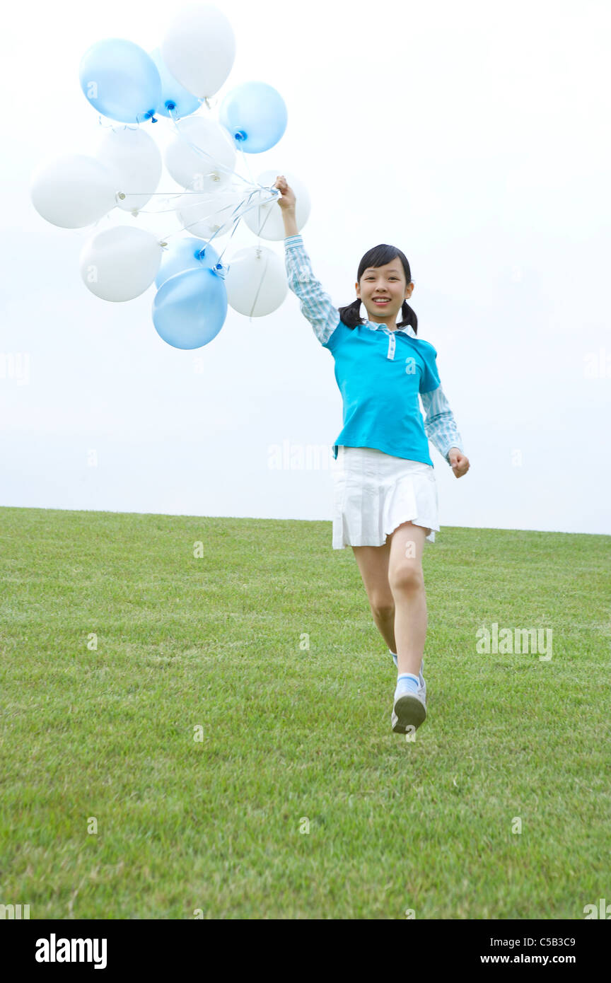 Ritratto di ragazza con palloncini sul prato Foto Stock