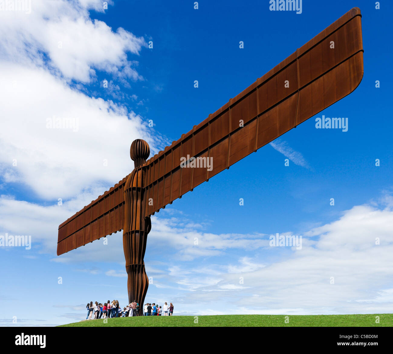 Turisti sotto l angelo della scultura del Nord di Antony Gormley, Gateshead, Tyne and Wear, North East England, Regno Unito Foto Stock