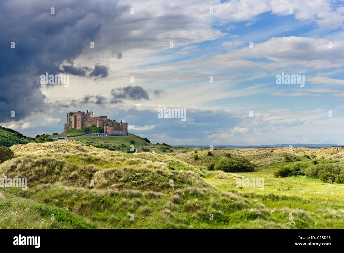 Vista sulle dune al castello di Bamburgh sulla costa di Northumberland, North East England, Regno Unito Foto Stock