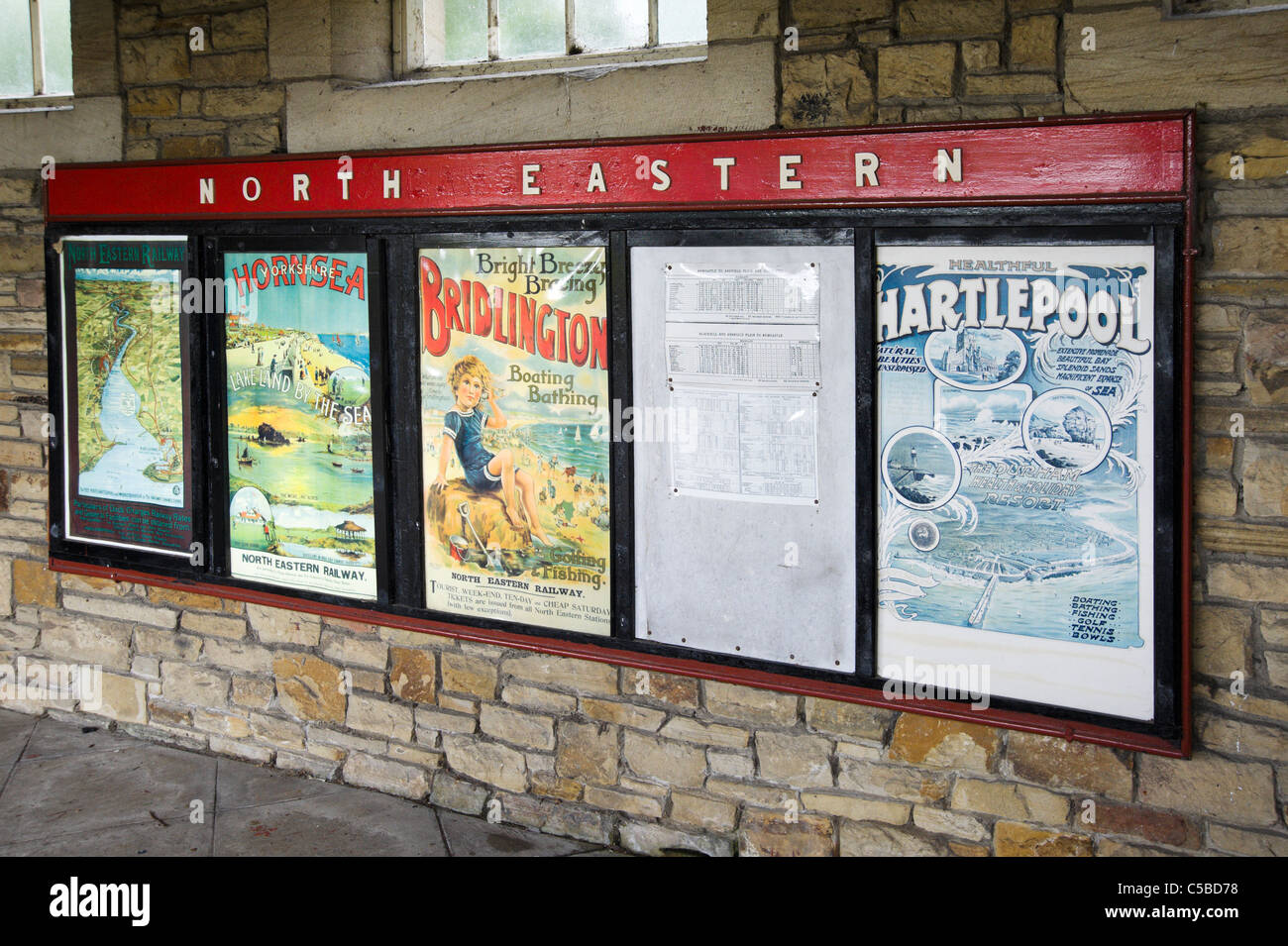 Vecchio poster sulla piattaforma presso la stazione ferroviaria, Beamish Open Air Museum, County Durham, North East England, Regno Unito Foto Stock