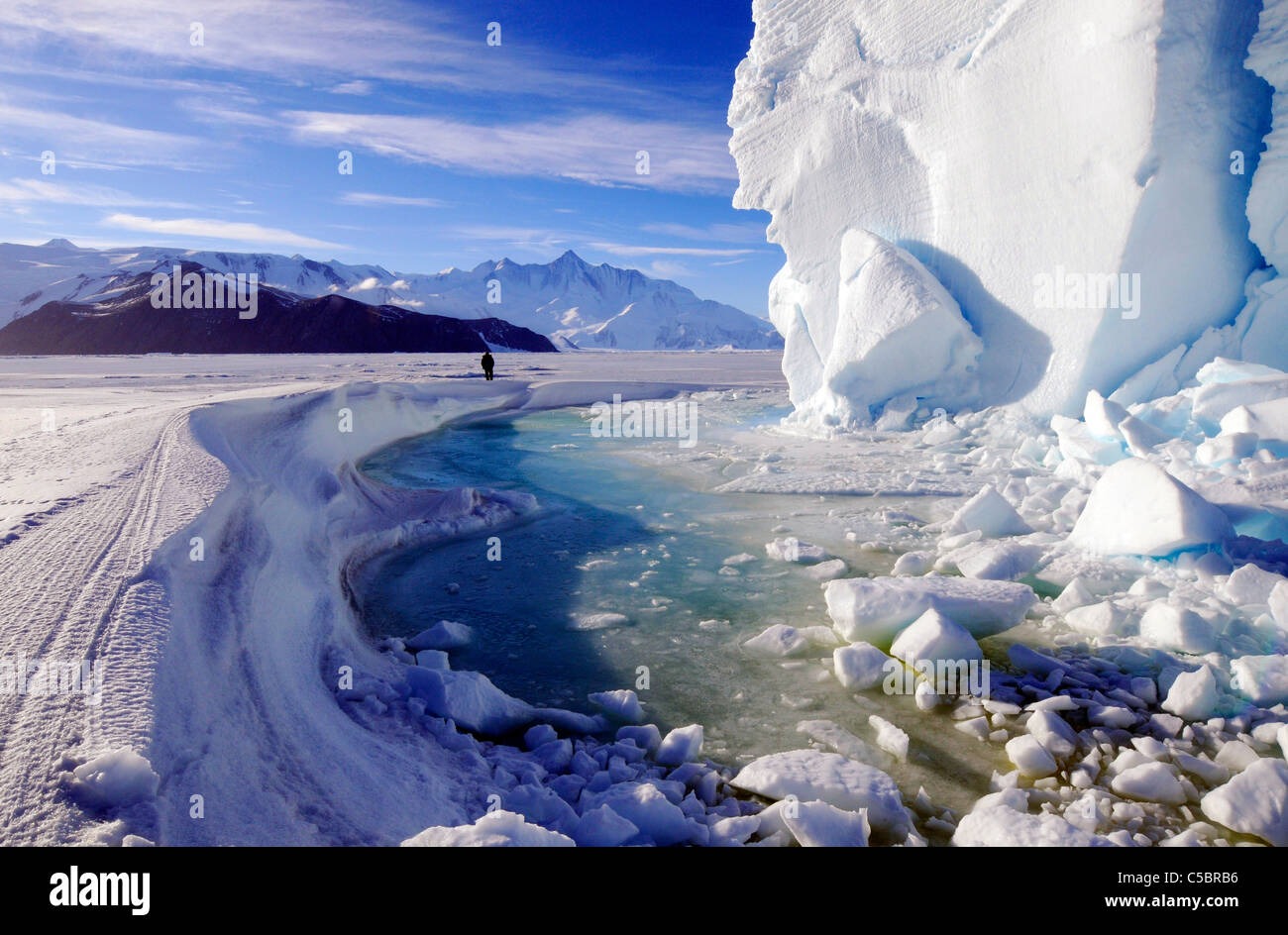 Montare Herschel con la persona, grande ice berg e alghe marine in piscina vicino a Cape Hallett settentrionale del Mare di Ross Antartide Foto Stock
