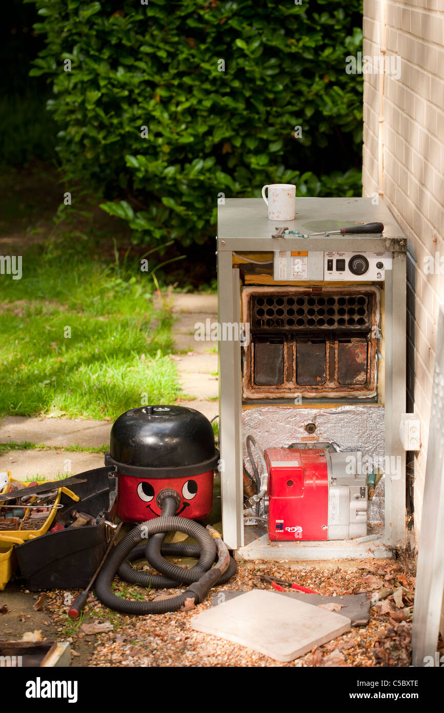 Un servizio di caldaia in corso. Nel mezzo di avere la caldaia riparata. Tazza di tè ubriaco. Foto Stock