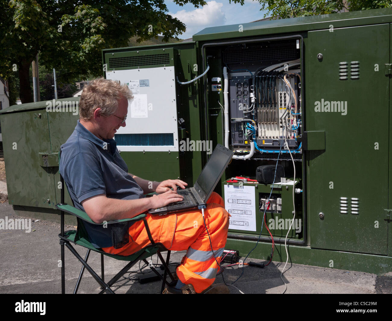 Ingegnere di aggiungere software alla fibra ottica della rete a banda larga la scatola di giunzione. Mossley,Lancashire,l'Inghilterra, Regno Unito. Foto Stock