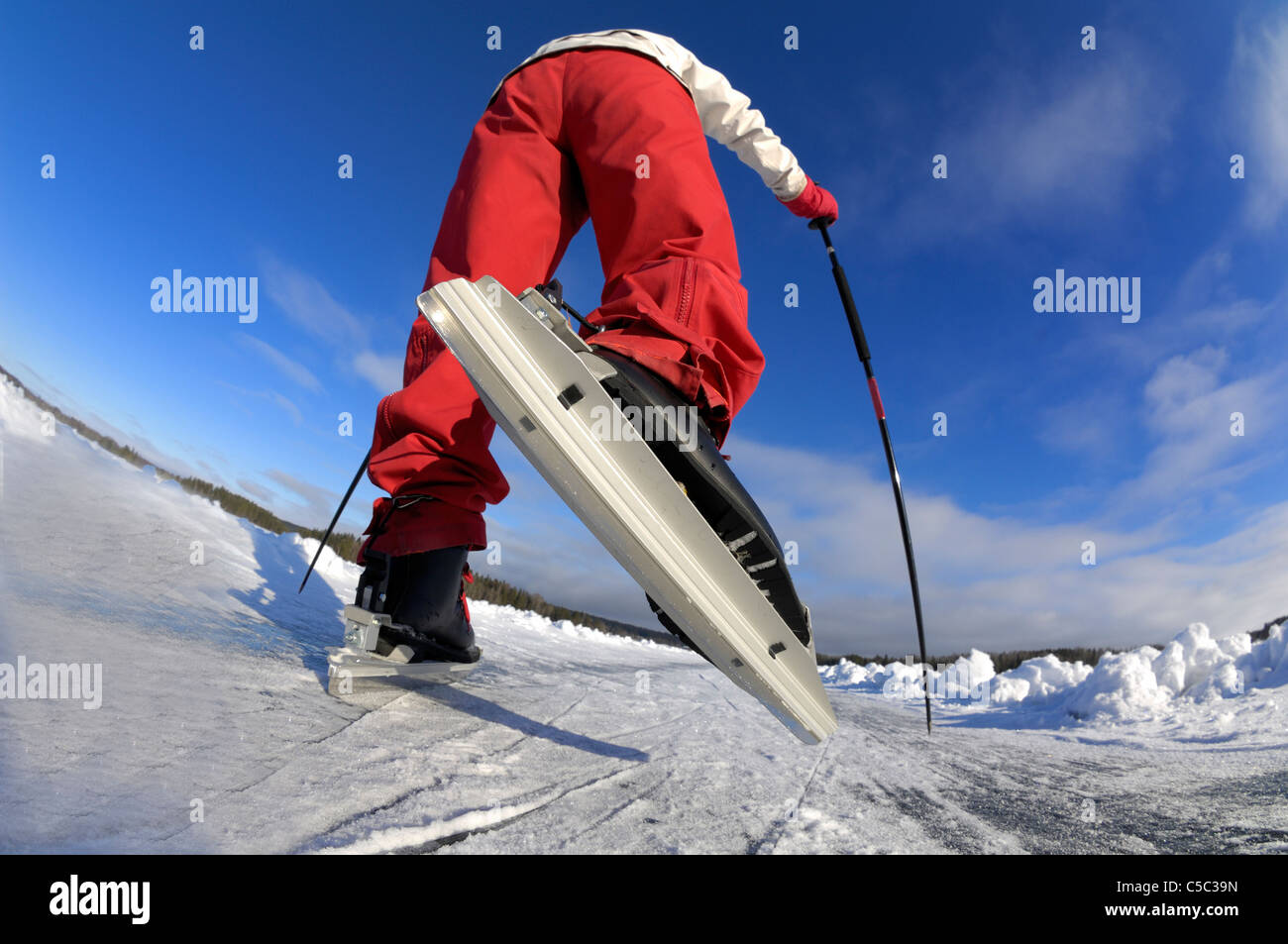 Angolo basso lente fish-eye di pattinaggio sul ghiaccio contro il cielo blu Foto Stock