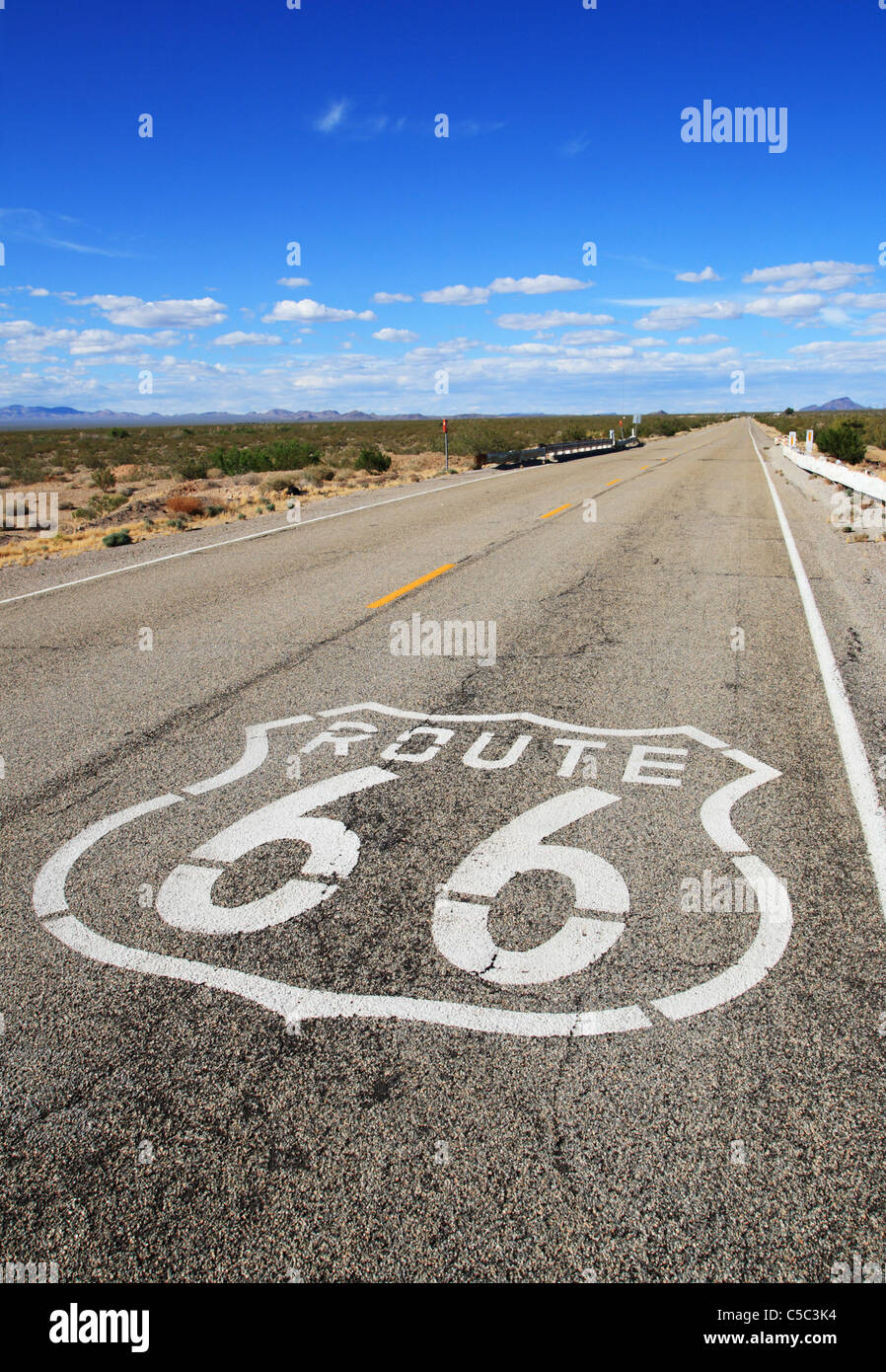 L'immagine verticale di route 66 strada che conduce verso il lontano orizzonte nel deserto di Mojave Foto Stock