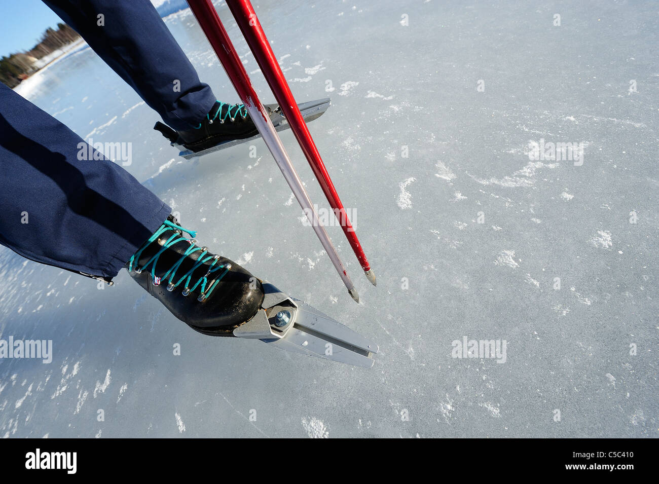 Sezione bassa di una persona pattinaggio sul lago ghiacciato Foto Stock