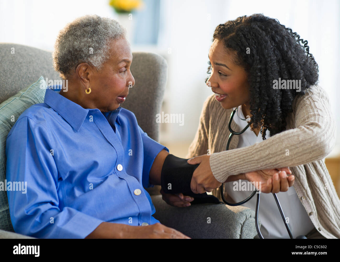 L'infermiera prendendo donna della pressione del sangue Foto Stock