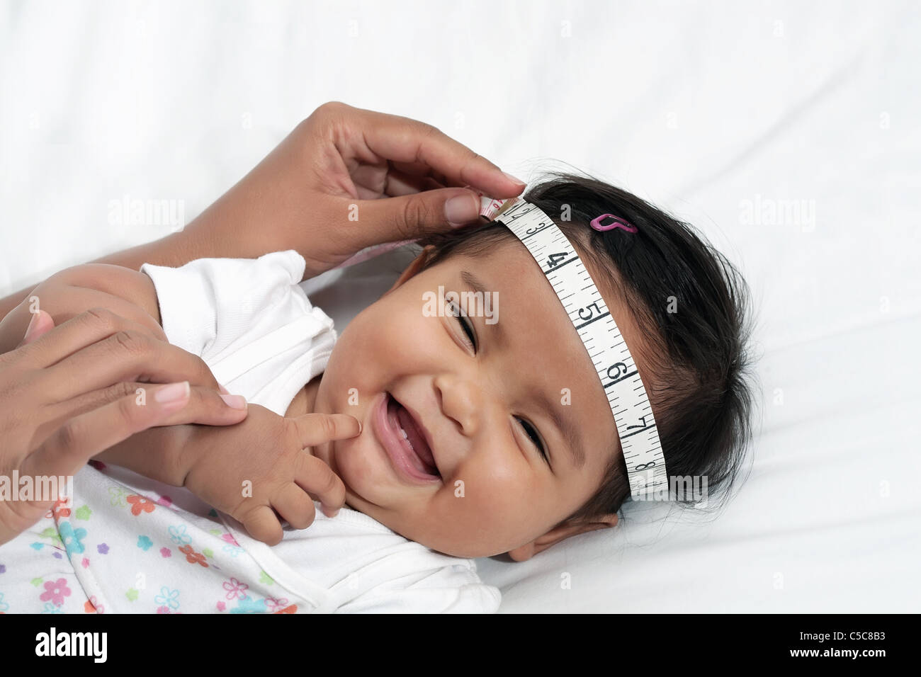 Happy Baby girl durante esame di routine, misurazione della testa Foto Stock