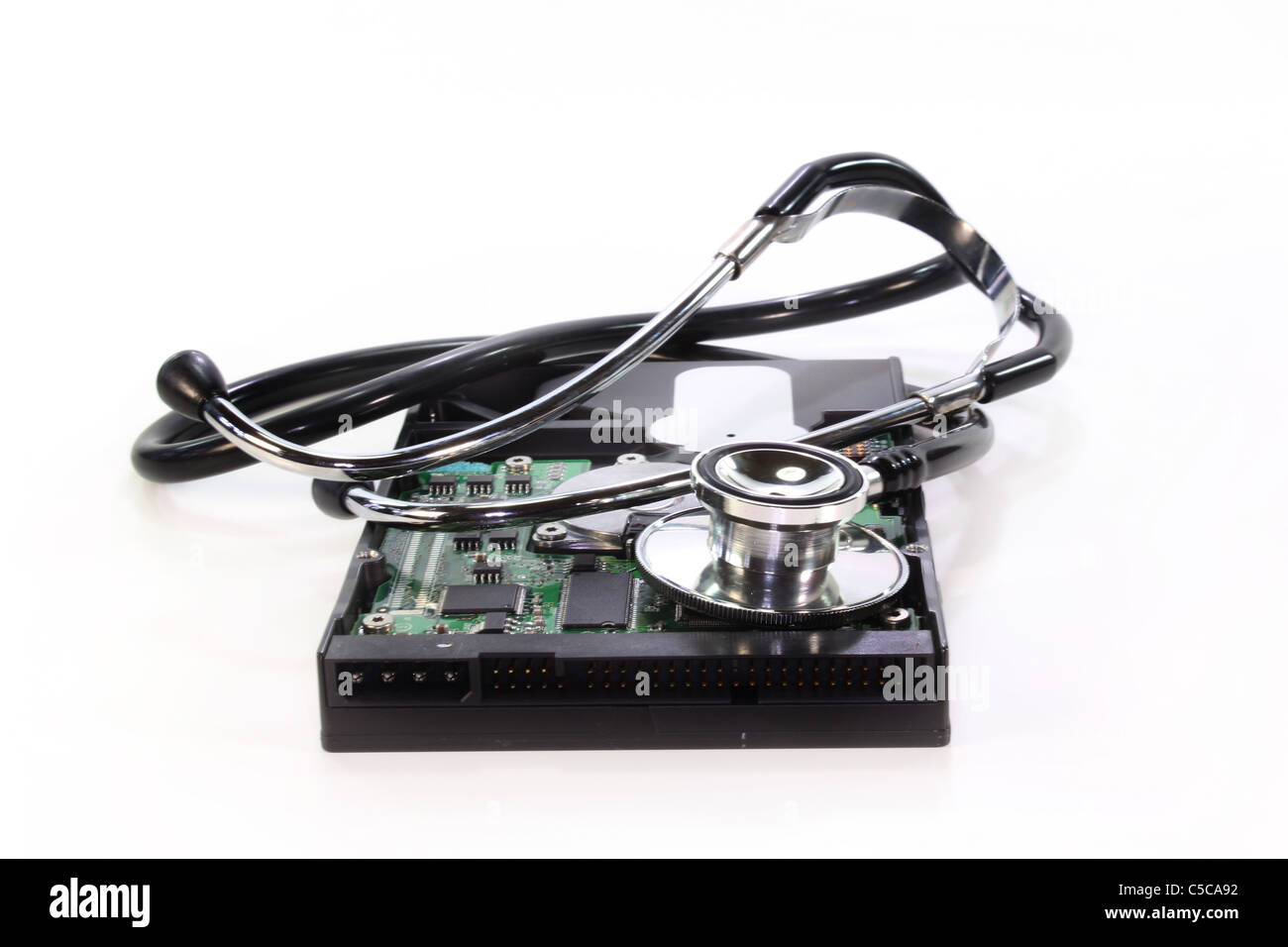 Un disco rigido e uno stetoscopio su sfondo bianco Foto Stock