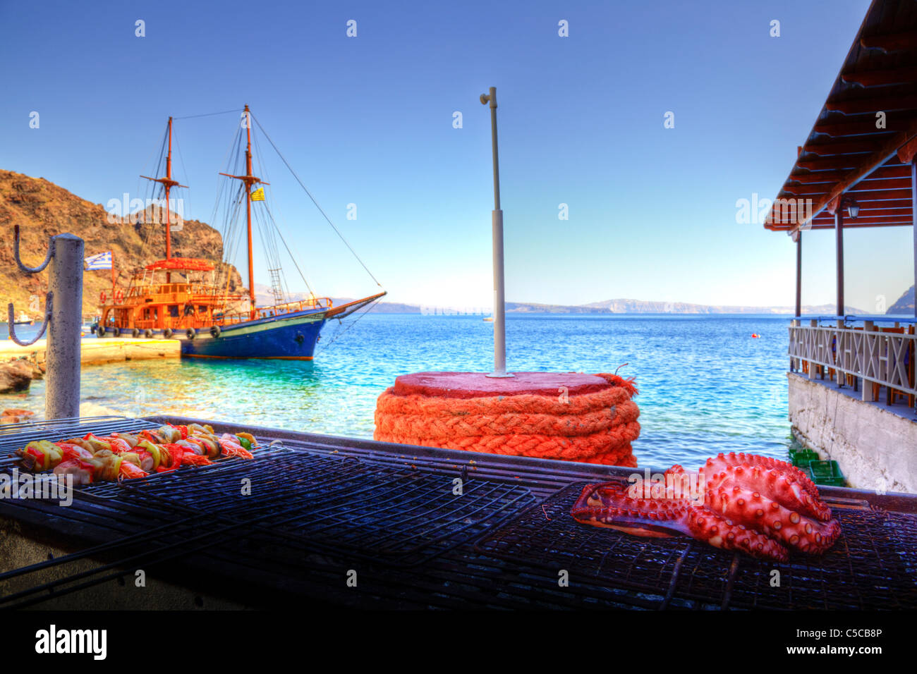 Polpo alla griglia e spiedini di gamberi sul barbecue a Santorini Grecia la cottura vicino al mare caldera cicladi Foto Stock