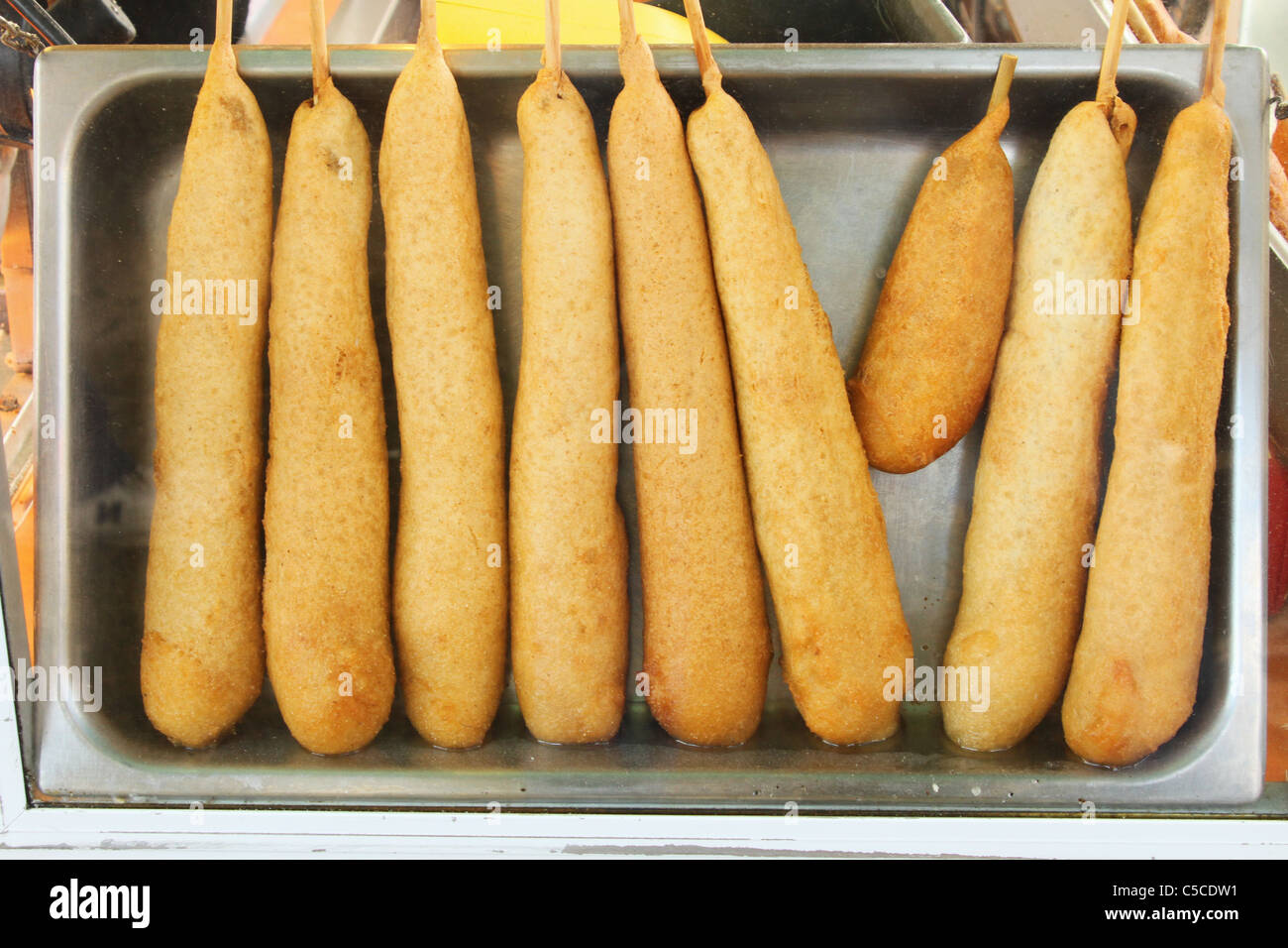 Corndogs in una vaschetta sotto il vetro. Foto Stock