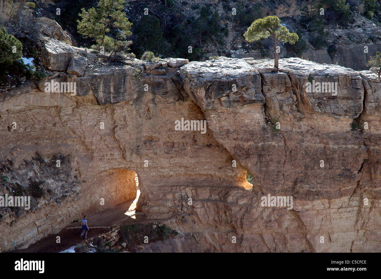 Un turista passeggiate attraverso un foro in una formazione rocciosa sul Bright Angel Trail vicino al Margine Sud del Grand Canyon. Foto Stock