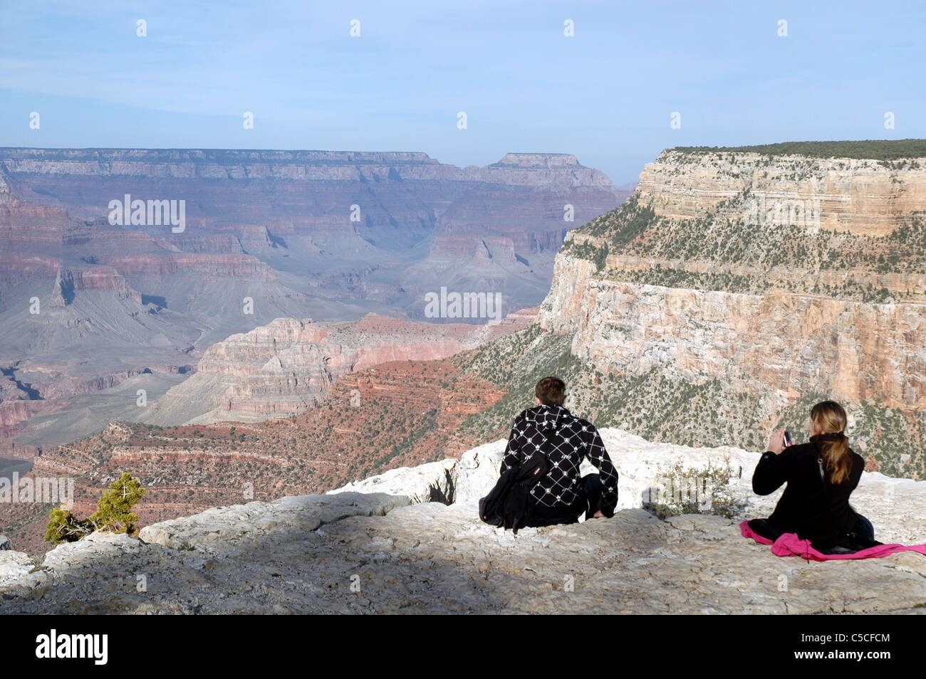 Una coppia di turisti stop per scattare foto e rilassarvi presso il Trailview si affacciano lungo il bordo meridionale del Parco Nazionale del Grand Canyon. Foto Stock