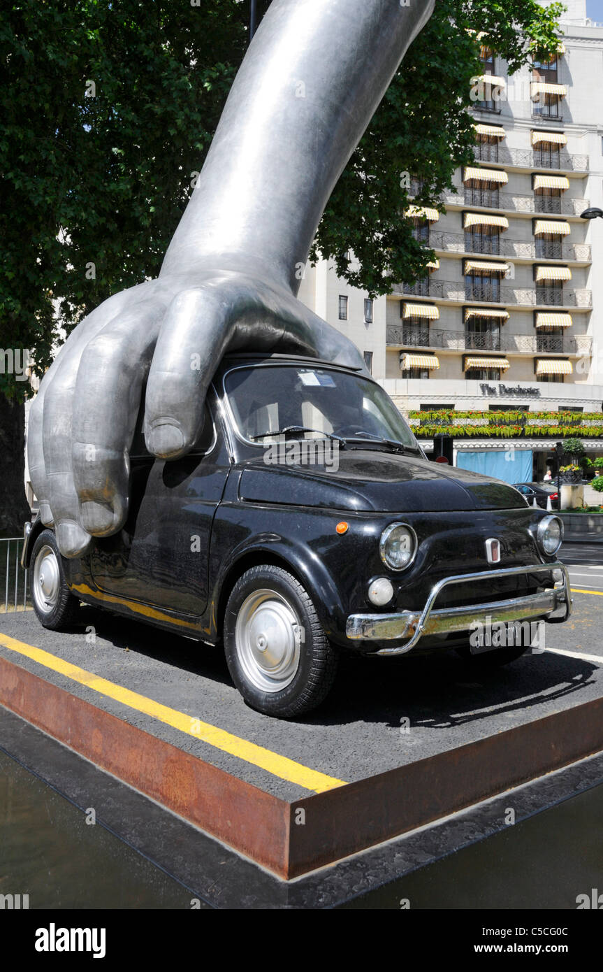 Mano sul Vintage Fiat Auto in arte moderna scultura "Vroom Vroom" dell'artista italiano Lorenzo Quinn fuori Dorchester Hotel di Mayfair London REGNO UNITO Foto Stock