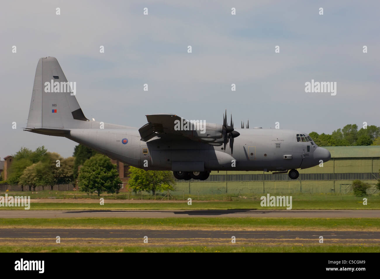 Lockheed C-130H Hercules i trasporti aerei volando a bassa quota sopra una pista di atterraggio. Foto Stock
