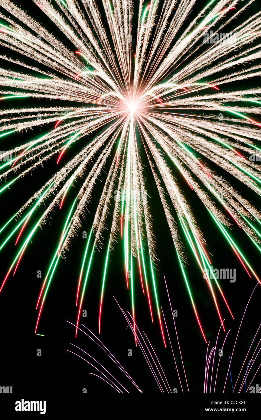 Bianco, verde, rosso e viola e fuochi d'artificio che esplodono nel cielo notturno. Una festa di colori e di esplosioni! Foto Stock
