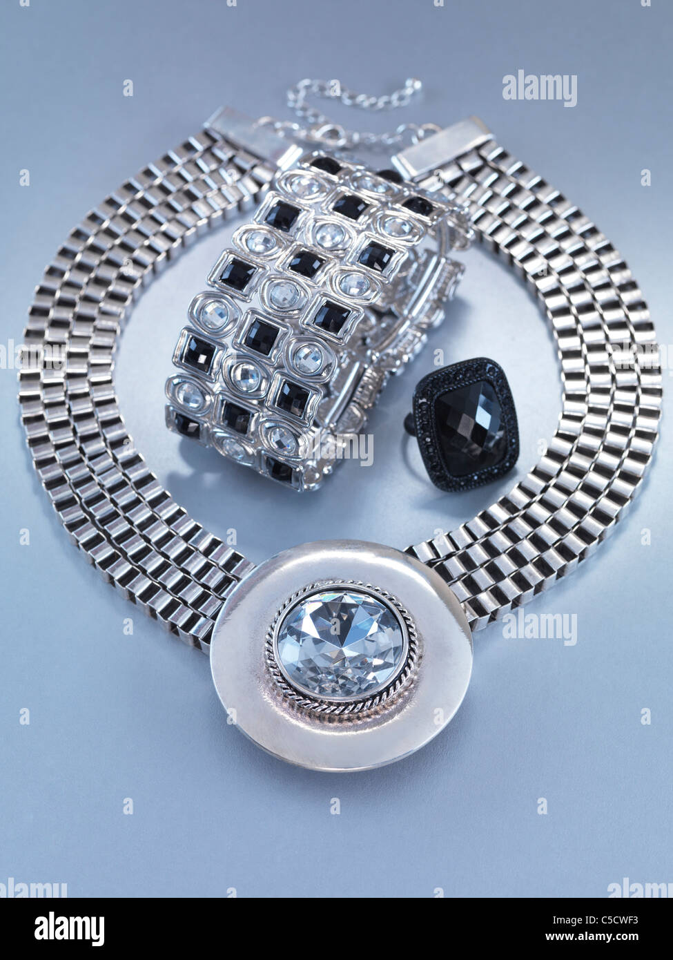 Girocollo con pendente, un bracciale e un anello gioielli isolati su sfondo grigio Foto Stock