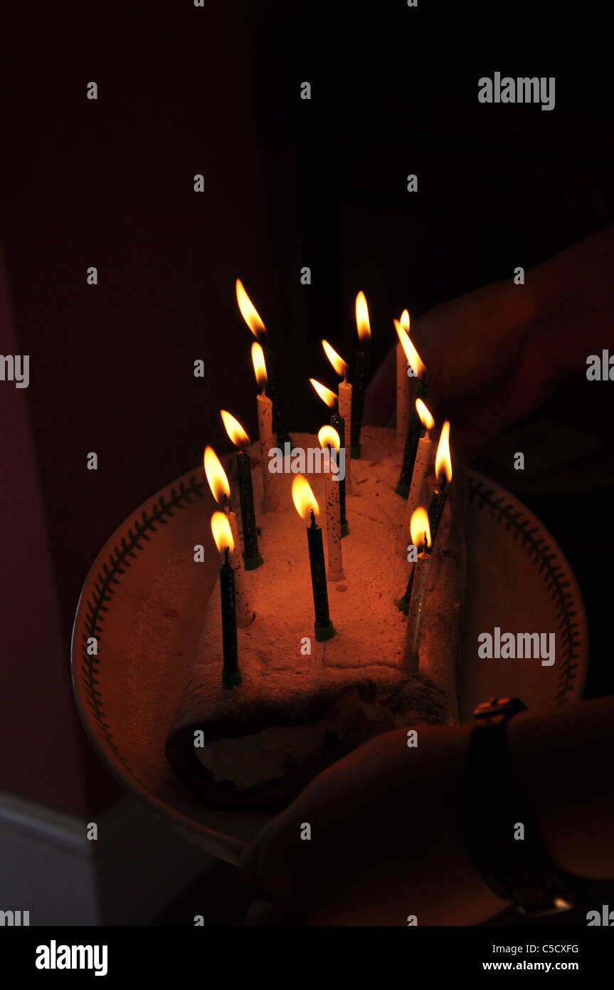 Le fiamme del compleanno candele su una torta di compleanno o involtino. Foto Stock
