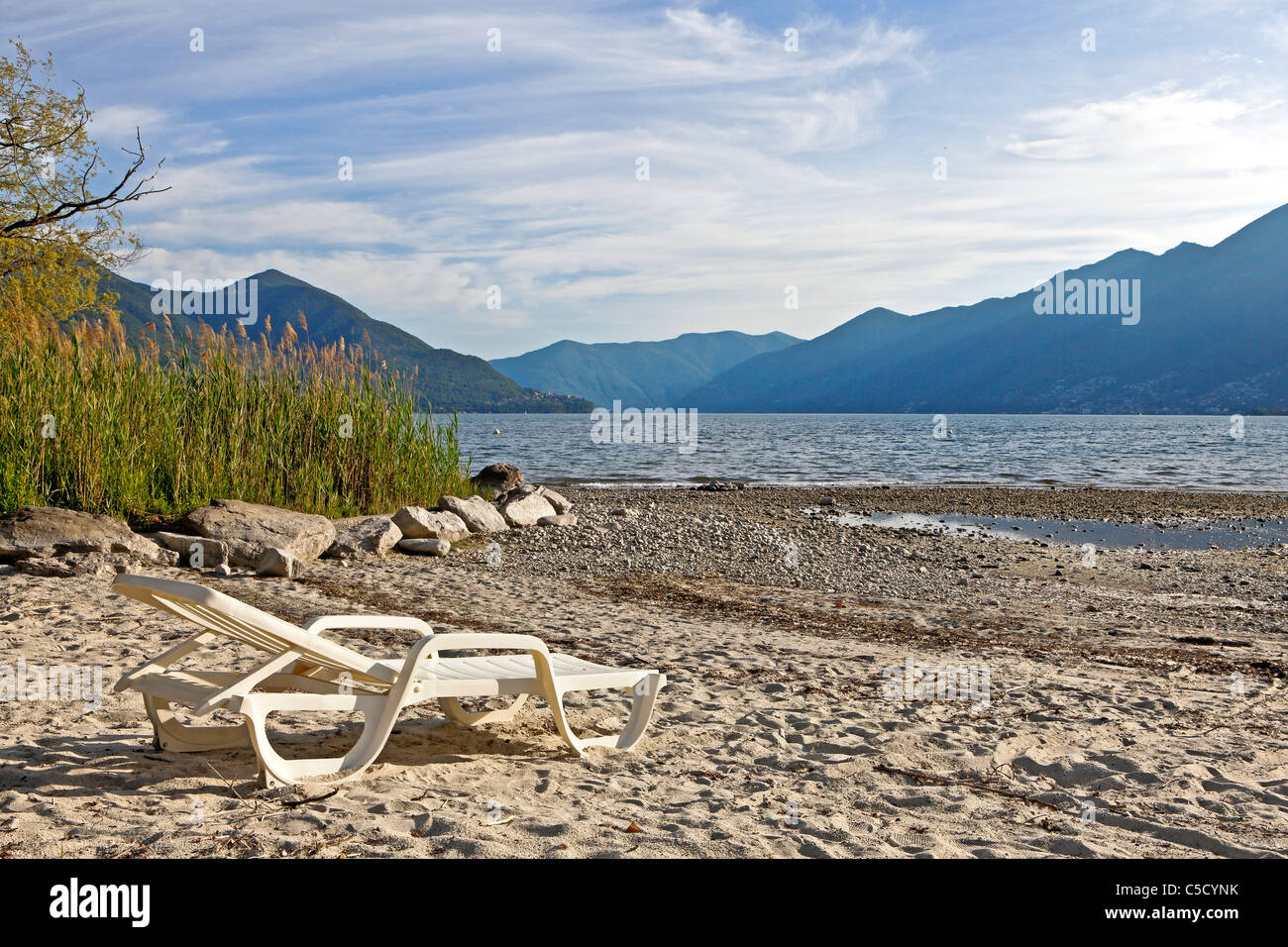 Una singola sedia a sdraio sulla spiaggia di Ascona sul Lago Maggiore Foto Stock