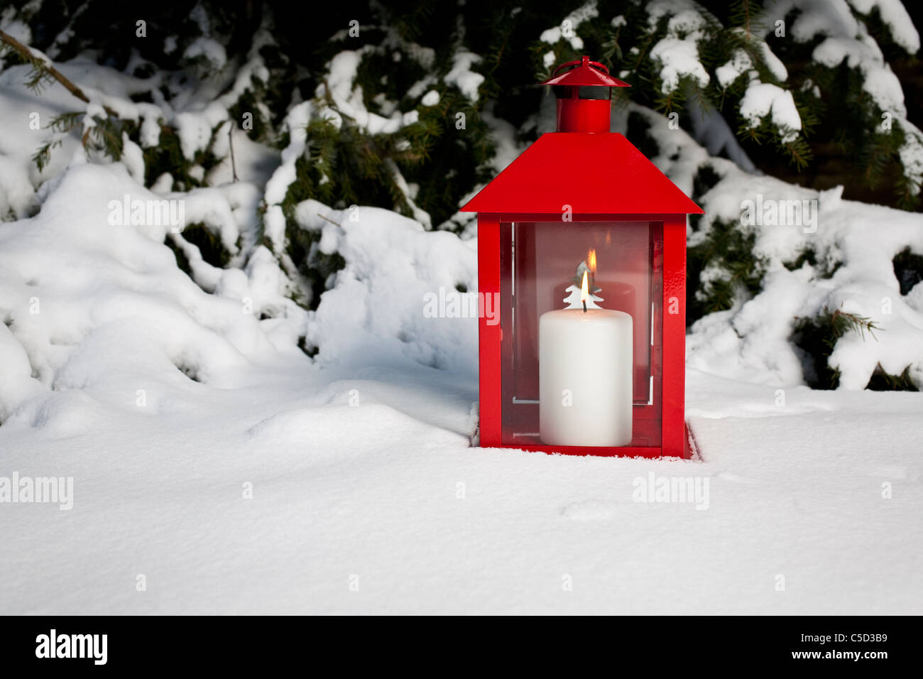 Close-up di candela accesa in rosso lanterna nella neve Foto stock - Alamy