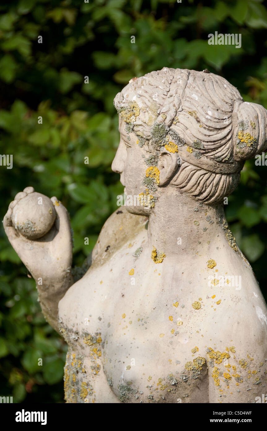 Un'elegante statua in pietra di una signora in un giardino paesaggistico Foto Stock