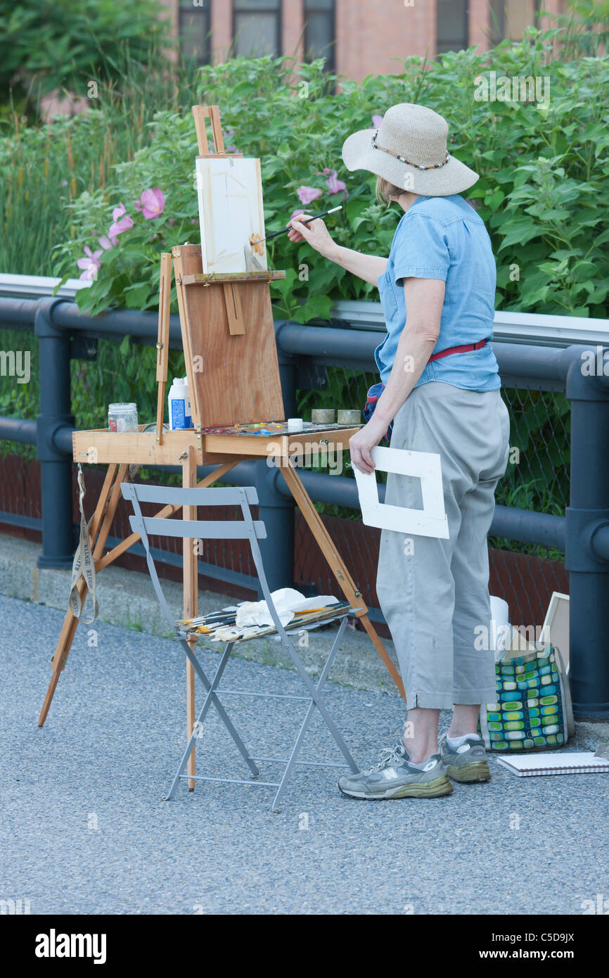 Un artista inizia un dipinto sulla linea alta nella città di New York. Foto Stock
