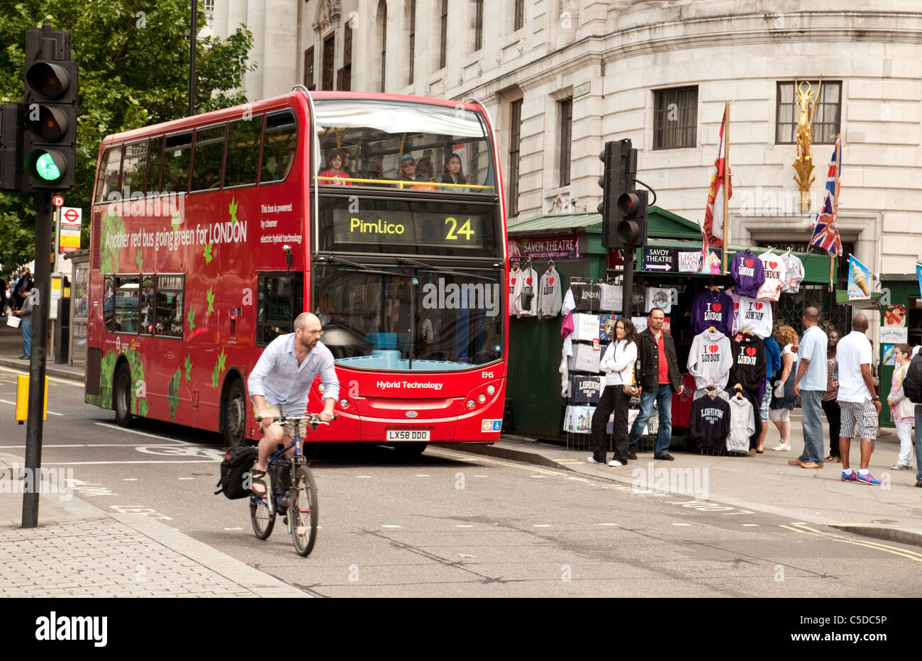 Un ciclista sulla sua bicicletta e un autobus di londra nel traffico sullo Strand, Londra centrale, Regno Unito Foto Stock