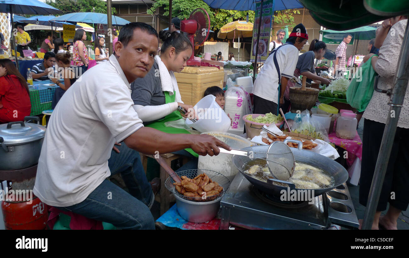 Thailandia Chiang Mai. Cucina di strada. L'uomo la frittura di pesce. Foto di Sean Sprague Foto Stock