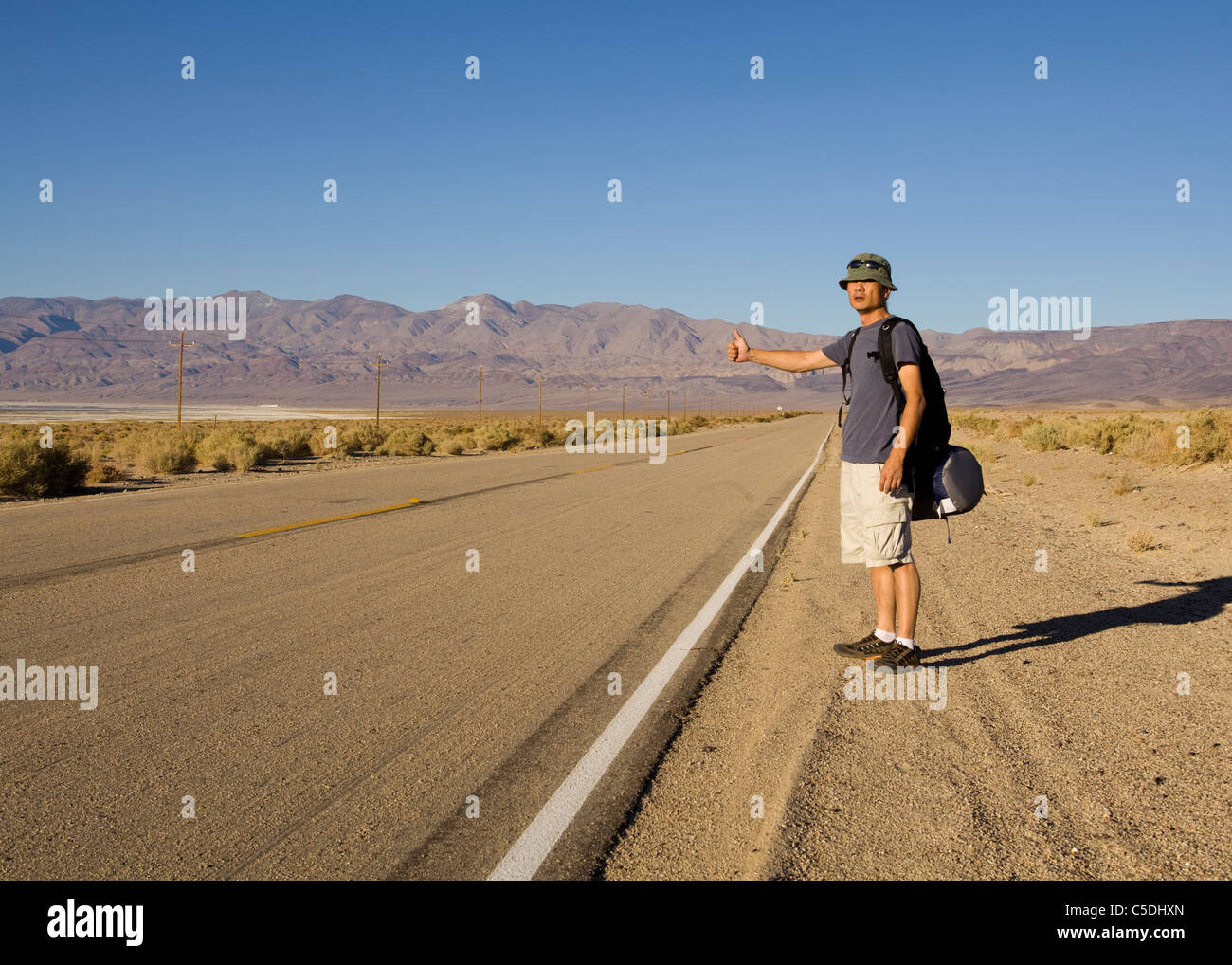 Un uomo autostop su rurale desert highway - California USA Foto Stock