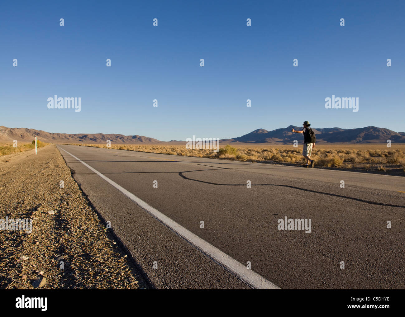Un uomo autostop su rurale desert highway - California USA Foto Stock