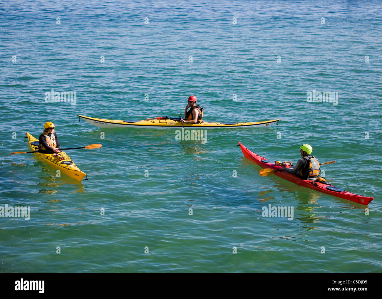 Tre kayakers resto in acqua calma Foto Stock