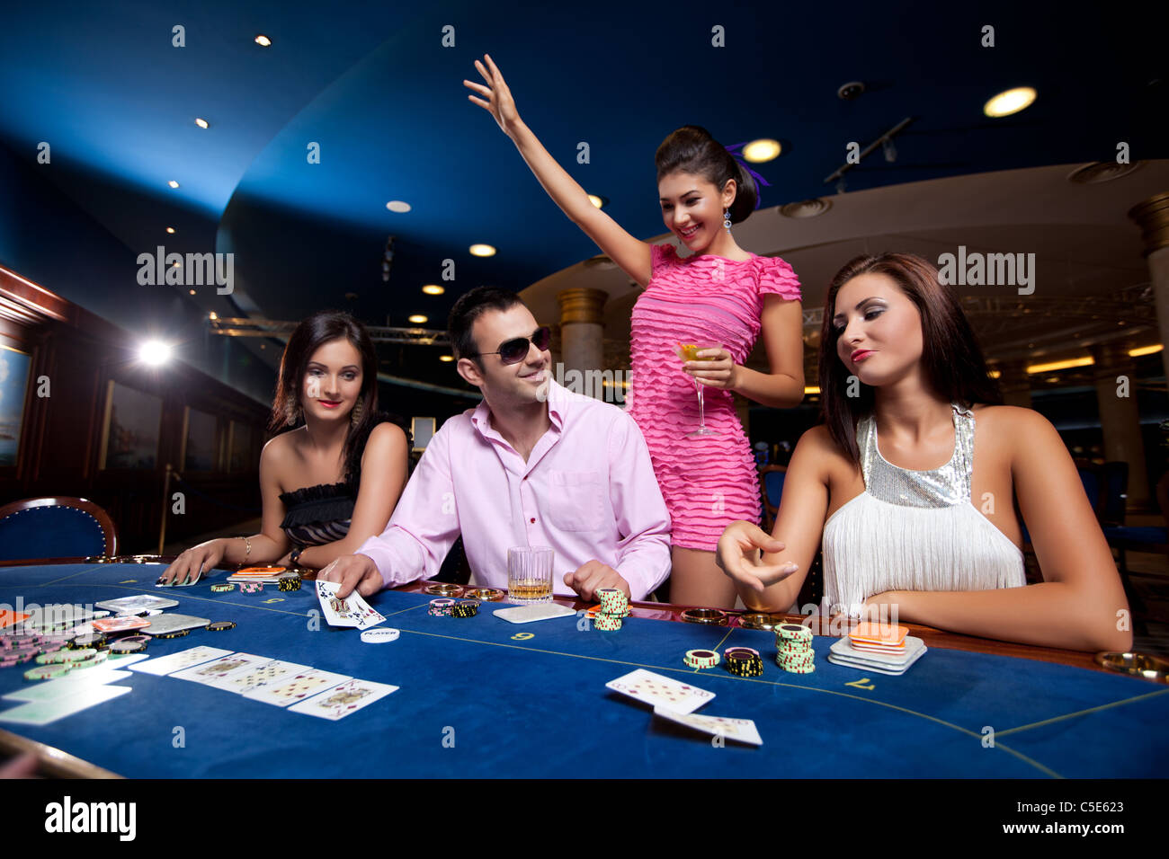 La gente seduta in un casinò e giocare a poker, Uomo con occhiali vincere Foto Stock