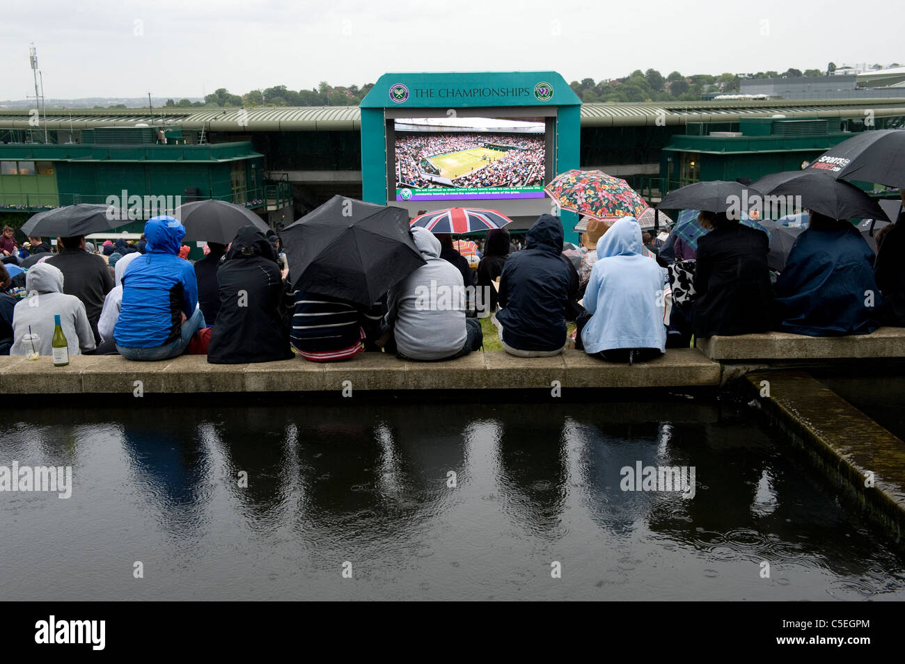 La folla guardare il grande schermo su Aorangi terrazza o Henman Hill sotto la pioggia durante il 2011 Wimbledon Tennis Championships Foto Stock