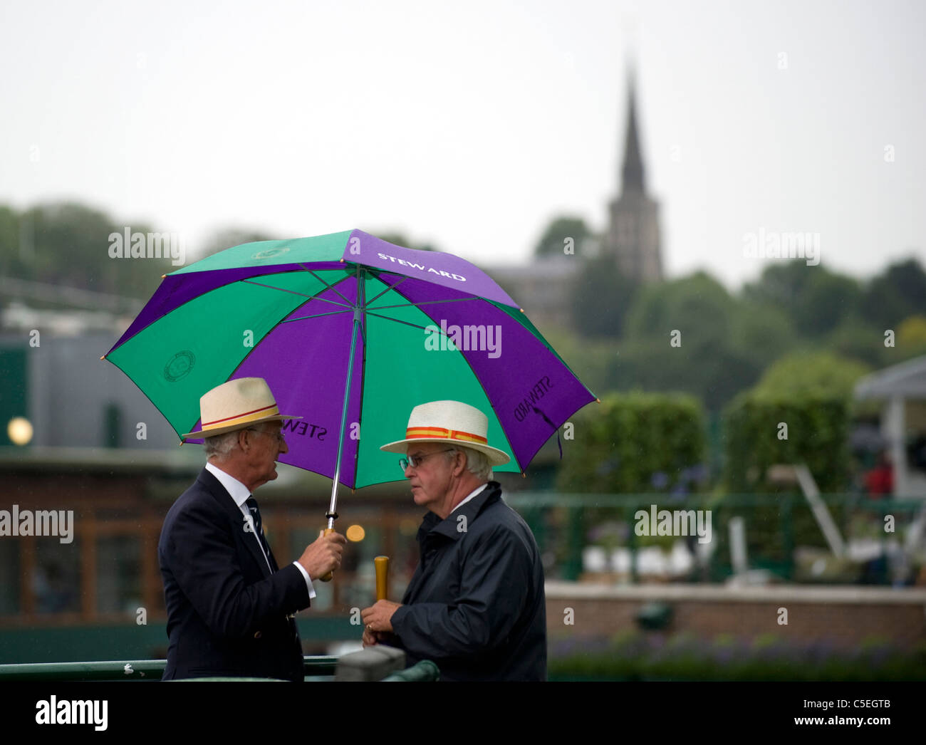 Steward tenere gli ombrelli sotto la pioggia durante il 2011 Wimbledon Tennis Championships Foto Stock