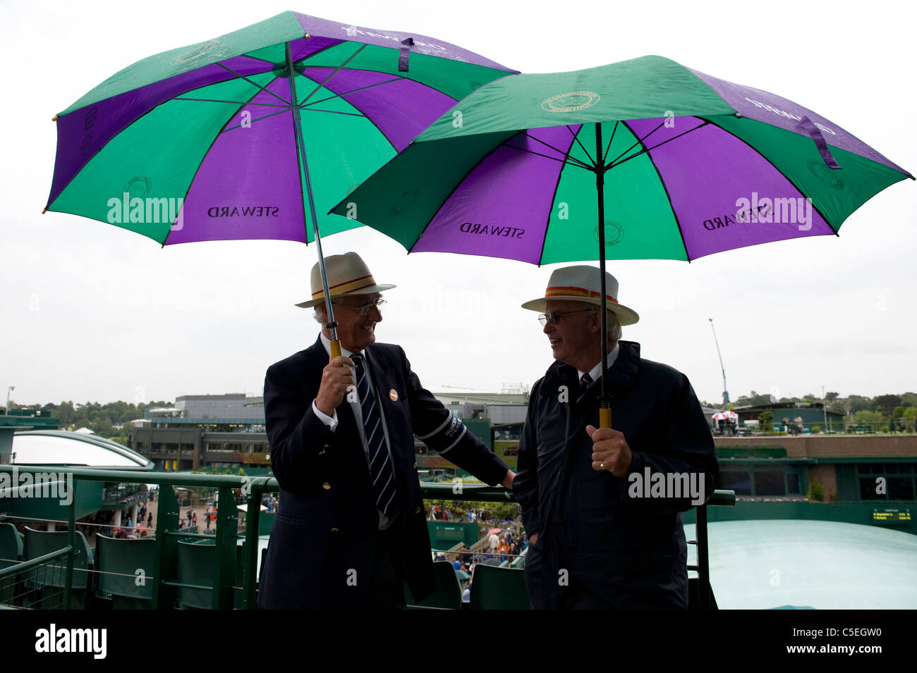 Steward tenere gli ombrelli sotto la pioggia durante il 2011 Wimbledon Tennis Championships Foto Stock