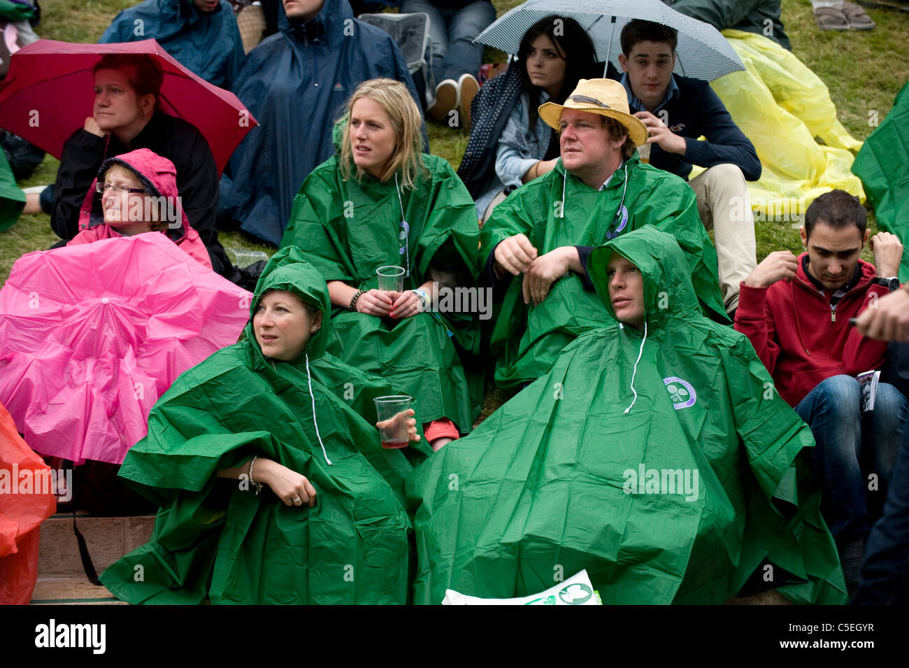 La folla guardare il grande schermo su Aorangi terrazza sotto la pioggia durante il 2011 Wimbledon Tennis Championships Foto Stock