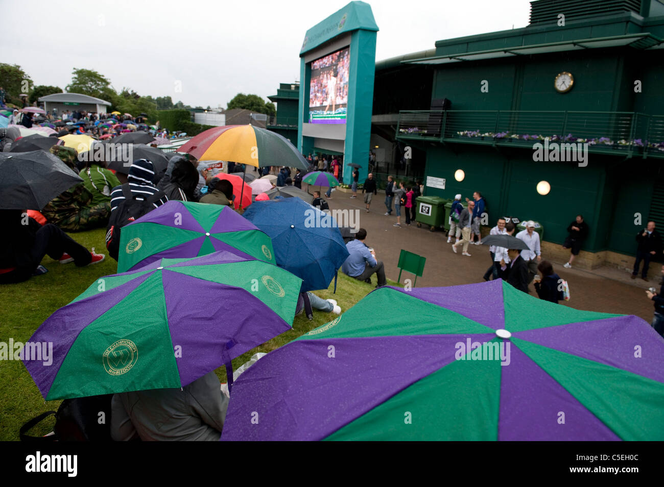La folla guardare il grande schermo su Aorangi terrazza sotto la pioggia durante il 2011 Wimbledon Tennis Championships Foto Stock