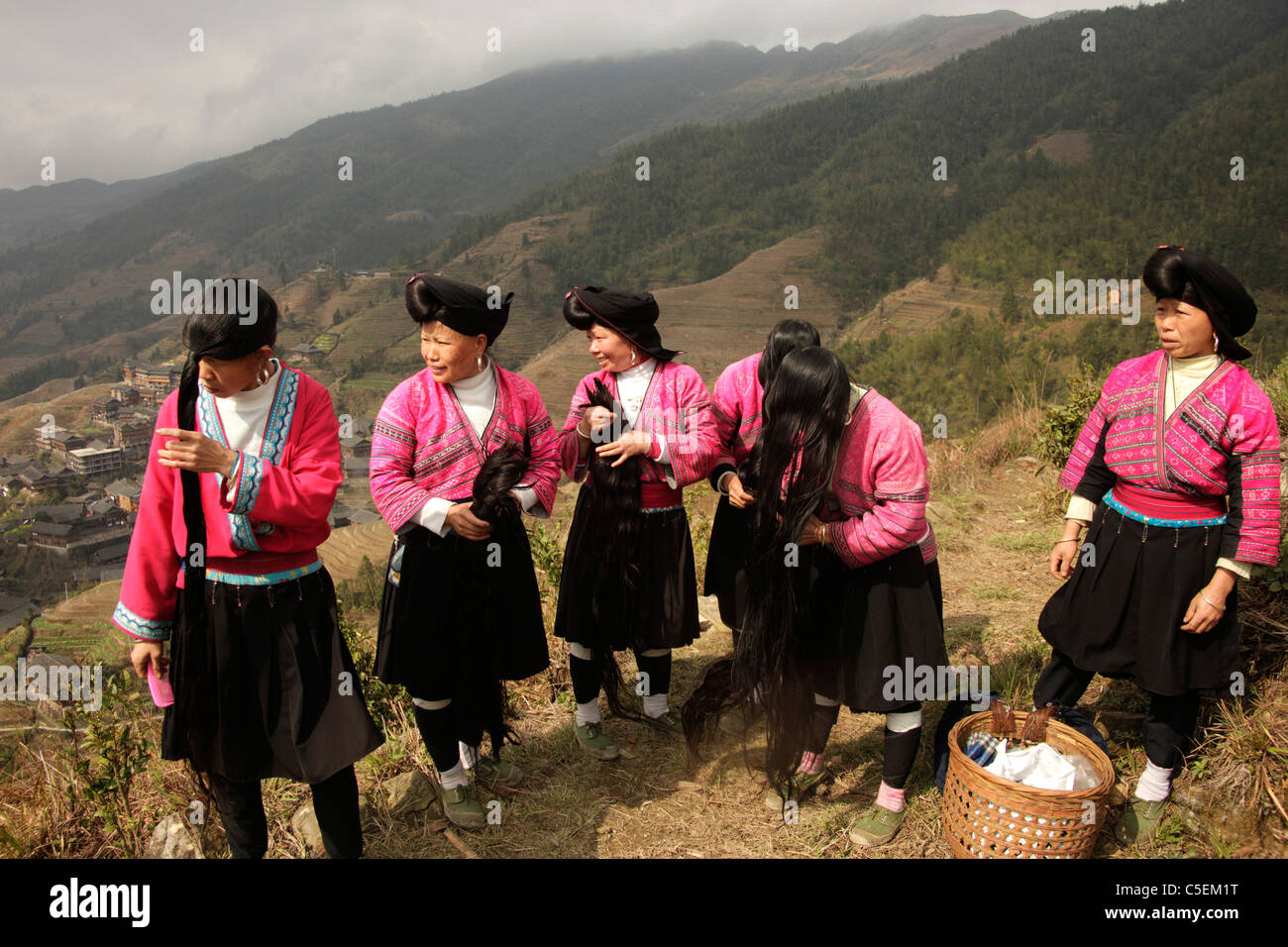 Le donne di Yao minoranza con costumi tradizionali e la loro caratteristica acconciatura a eseguire il ping di un vicino a Longsheng, Guangxi, Cina Foto Stock
