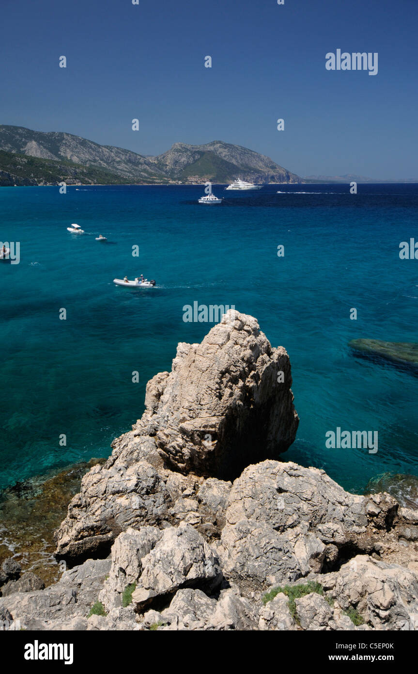 Rocce bianche,yachts e dello zodiaco in barca a vela nelle acque trasparenti a Cala Luna, Cala Gonone, Sardegna, Italia Foto Stock