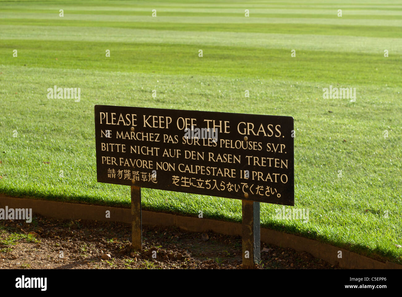 Si prega di mantenere spento il segno di erba in più lingue nella parte anteriore del prato verde del King's College di Cambridge Foto Stock