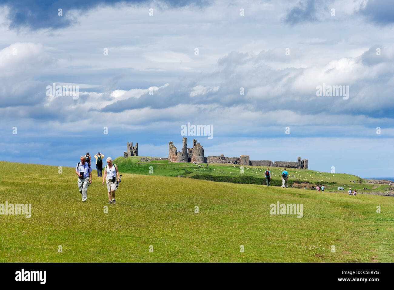 Walkers sul percorso tra Craster e Castello di Dunstanburgh sulla costa di Northumberland, North East England, Regno Unito Foto Stock