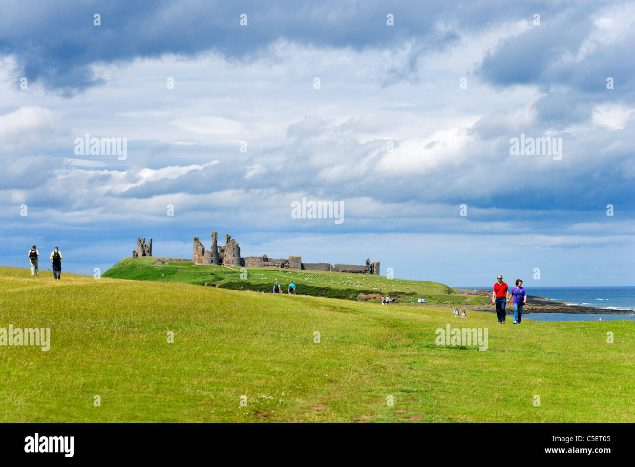 Walkers sul percorso tra Craster e Castello di Dunstanburgh sulla costa di Northumberland, North East England, Regno Unito Foto Stock