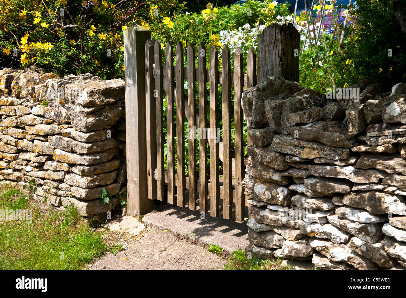 Cottage di campagna con mura in pietra e cancello in legno.Il formato orizzontale.copia dello spazio. Foto Stock