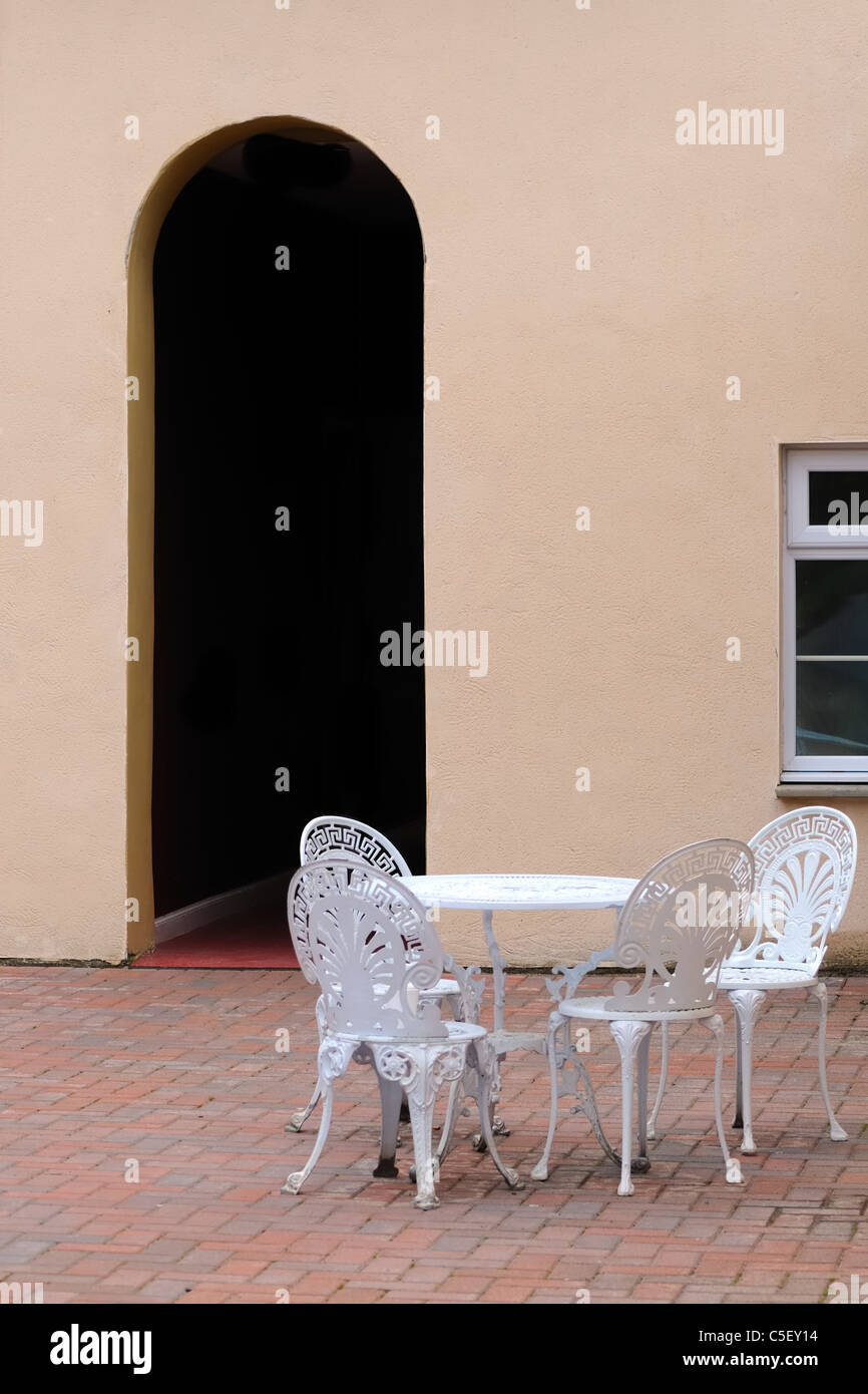 Tavolo e sedie nel cortile con il portale ad arco Foto Stock