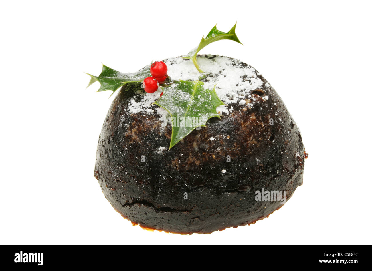 Pudding natalizio spolverato con zucchero e decorate con un rametto di agrifoglio Foto Stock