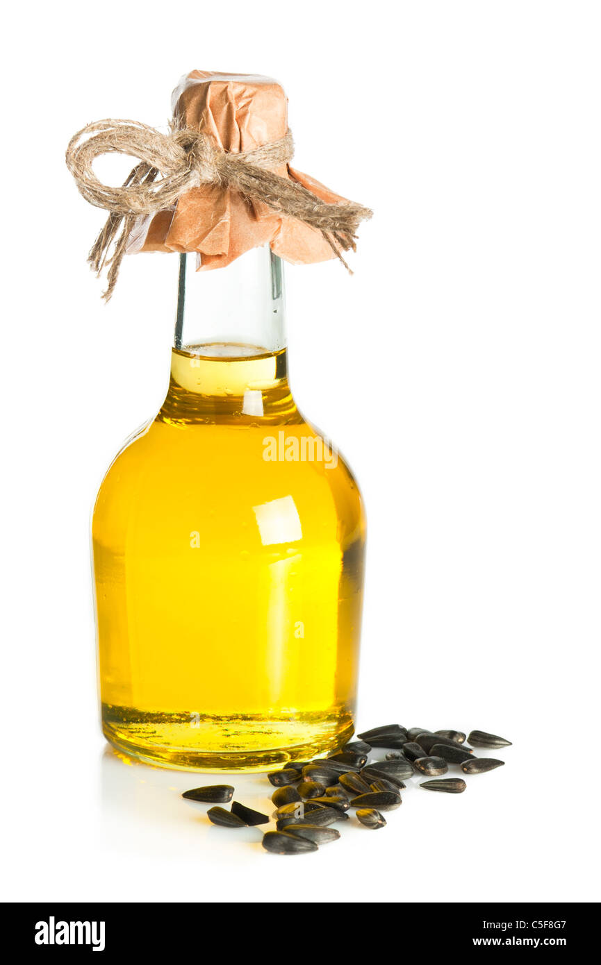 Bottiglia di olio di semi di girasole e semi su sfondo bianco Foto Stock