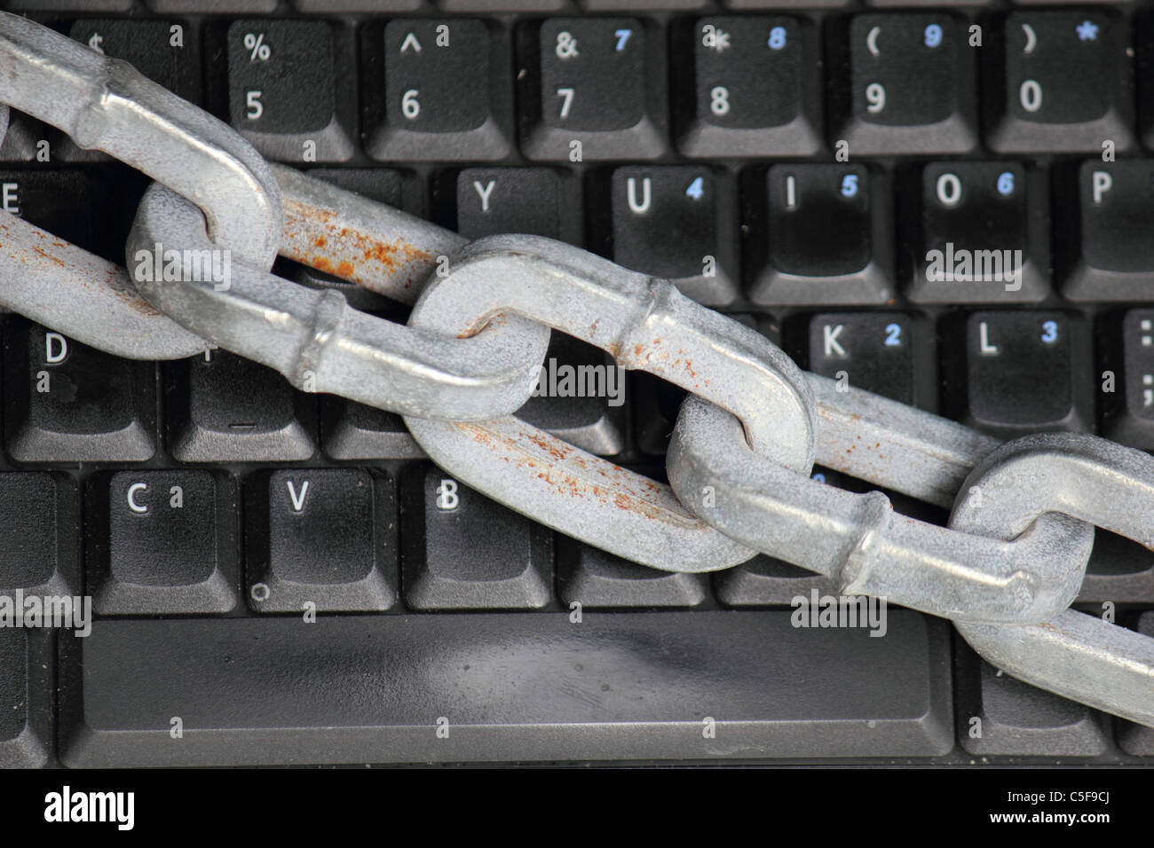 Un computer portatile / computer tastiera bloccata con una spessa catena pesante , immagine concettuale Foto Stock