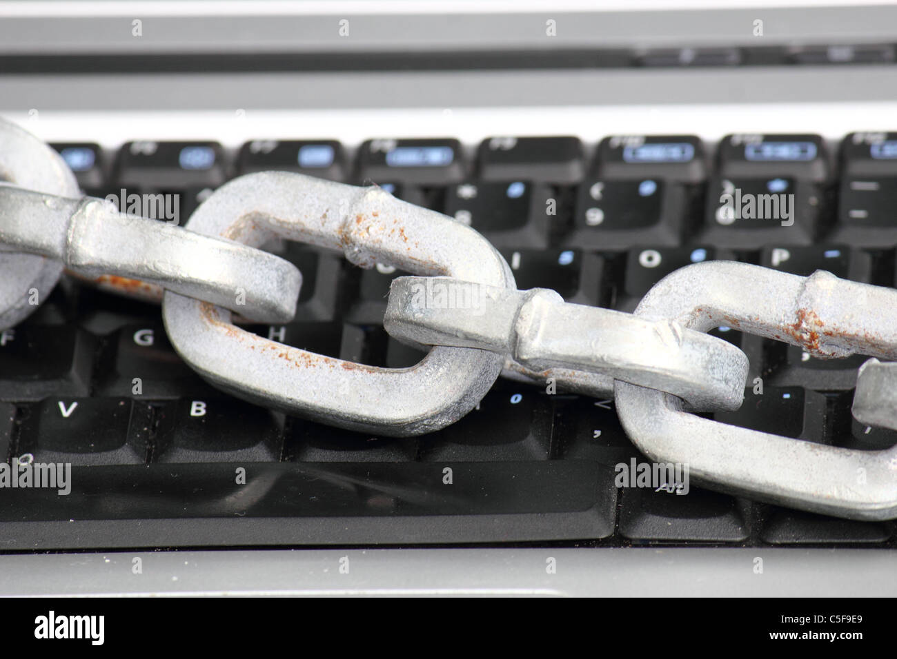 Un computer portatile / computer tastiera bloccata con una spessa catena pesante , immagine concettuale Foto Stock