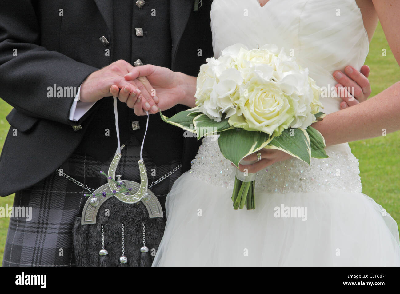 Gli sposi ad un matrimonio tenendo le mani. Foto Stock