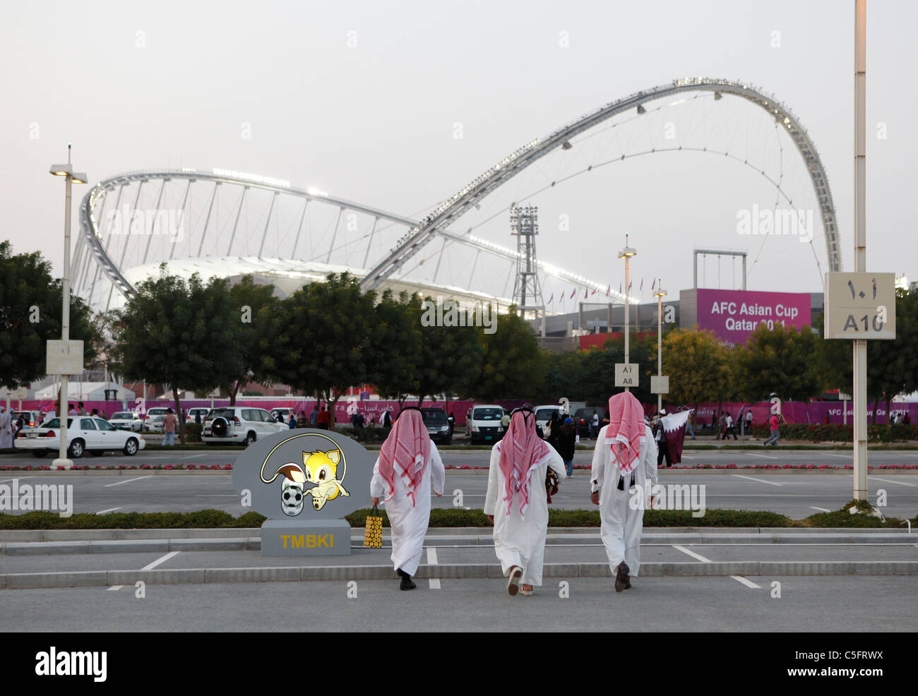 Tre locali a piedi Al Khalifa International Stadium per assistere a una partita di calcio Foto Stock